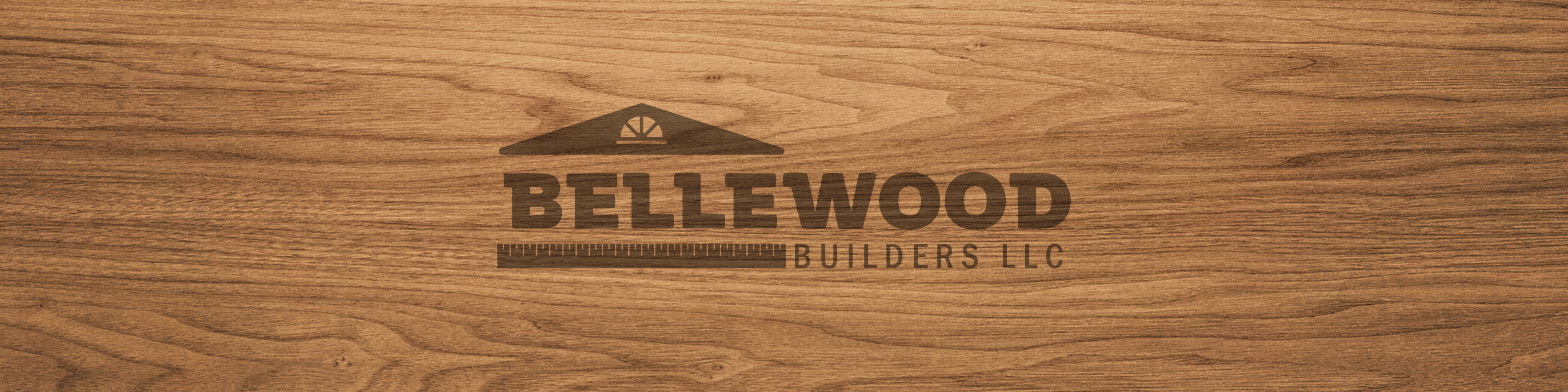 Bellewood Builders logo burned onto wood panel background